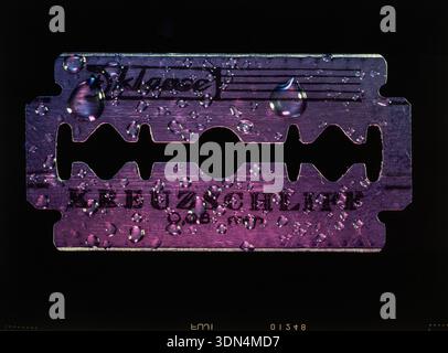 Close-up of a razor blade with water droplets on a black background. Stock Photo