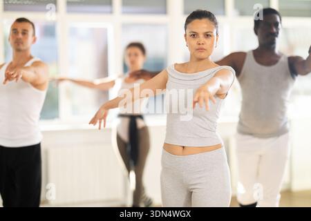 Concentrated women and men rehearsing ballet dance in class Stock Photo