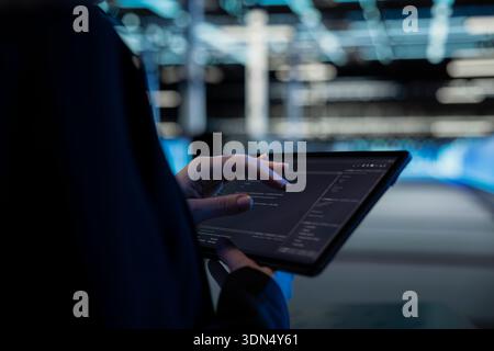 Close up of tablet used by data center computer scientist to write code, updating infrastructure network systems. Server hub worker typing on touchscreen device, coding upgrades Stock Photo