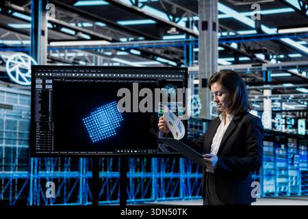 Server room manager looking over system benchmarks results after doing wireframe mesh mapping with AI. Woman in data center reading report files of deep learning gear digital twin scan results Stock Photo