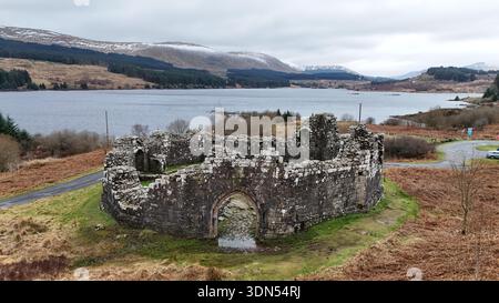 Loch Doon Castle ruins beside Loch Doon with surrounding hills and water under an overcast sky, Ayrshire, Scotland. Stock Photo