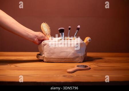 A wooden hairbrush, a wooden roller for a regenerating facial massage, lymphatic drainage, and anti-wrinkle treatment, bamboo makeup brushes in a Stock Photo