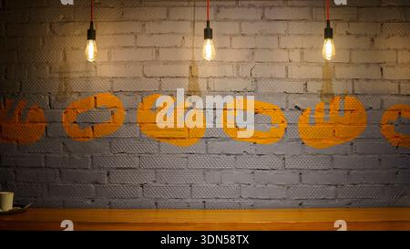 Interior texture background of a grey painted brick wall decorated with warm hanging electric light bulbs in a modern loft-style cafe. Stock Photo