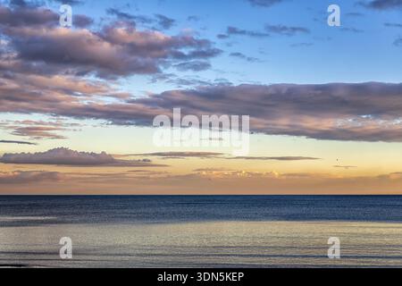 Beautiful colorful clouds over the sea. Stunning sky after sunset Stock Photo