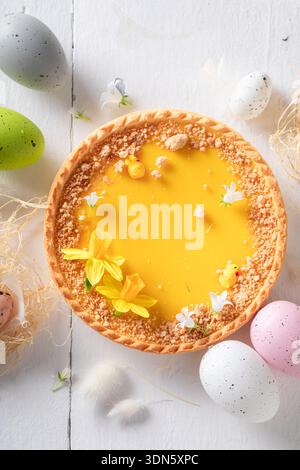 Fresh Mazurka cake surrounded by spring flowers and eggs. Easter spring background with flowers and easter eggs. Stock Photo