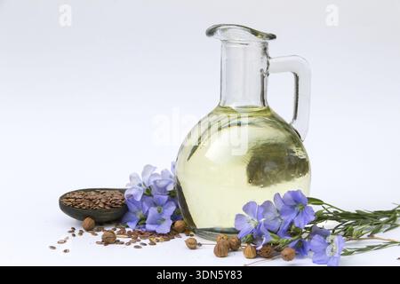 Flax oil bottle with flowers and seeds isolated on white background Stock Photo