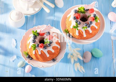 Sweet ring cake for Easter on holiday table with decorations. Easter treat and holiday decorations. Stock Photo