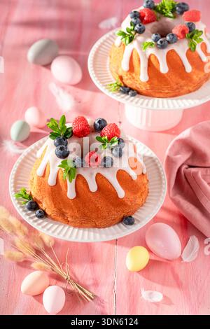 Delicious ring cake for Easter on holiday table with decorations. Easter spring background with flowers and easter eggs. Stock Photo