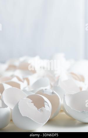 Eggshells lay on a kitchen counter after food preparation. They are broken and scattered, showing the process of cooking. Stock Photo