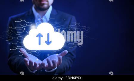 Man in suit shows cloud symbol with upload and download arrows in hands at night Stock Photo