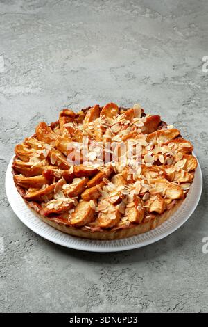 Fresh apple pie with almond topping on a gray surface Stock Photo