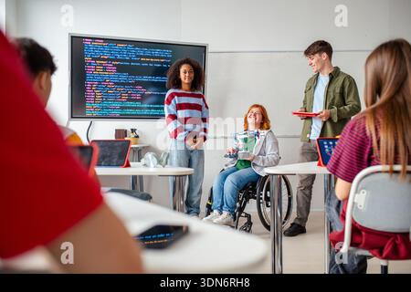 Inclusive student team presenting technology project in class. Stock Photo