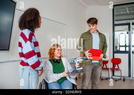 Inclusive student team presenting technology project in class. Stock Photo