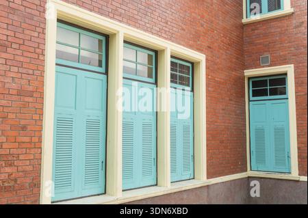 Vintage red brick wall with classic light blue wooden windows Stock Photo