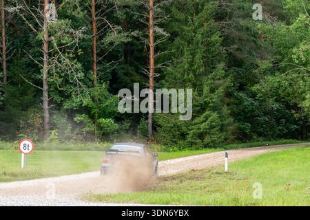 Paide, Estonia - August 23, 2025: Rally car speeds into turn on dirt road sending dust stones and mud into air during Estonian Rally Championship Humu Stock Photo