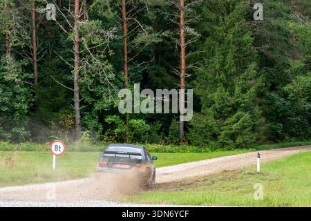 Paide, Estonia - August 23, 2025: Rally car speeds into turn on dirt road sending dust stones and mud into air during Estonian Rally Championship Humu Stock Photo