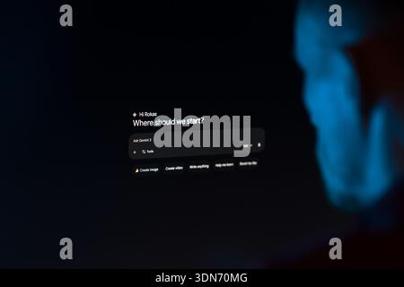 The Gemini AI interface with the prompt "Where should we start?" displayed on a screen in a dark room. Stock Photo