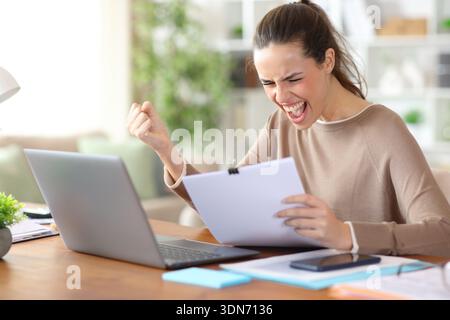 Excited self employed reading inform and celebrating success working at home Stock Photo