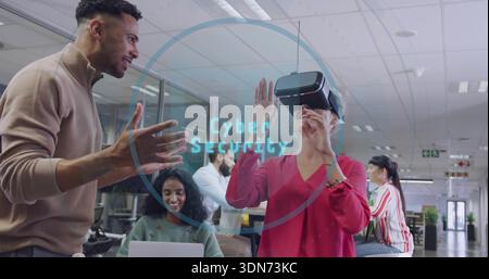 Showing woman red blouse using VR during open-plan office demo, laptop and Cyber Security graphic Stock Photo