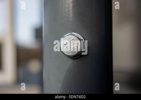 Close-up of a hexagonal bolt secured in a metal support structure with shallow depth of field. Stock Photo