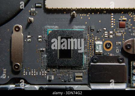 Close-up of a central processor chip mounted on a motherboard with surrounding electronic components. Stock Photo