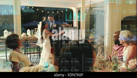 Dancing bride in white gown, groom in dark suit twirling on reception floor, with trading overlay Stock Photo