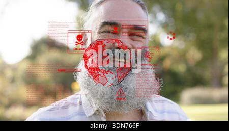 Smiling mature man with grey beard wearing thin-striped shirt in park, showing red malware overlay Stock Photo