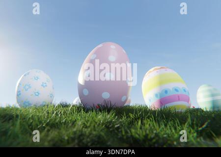 Close-up of decorative Easter eggs with pastel polka dots and floral patterns nestled in green grass. Eggs with a clear blue sky background, perfect f Stock Photo
