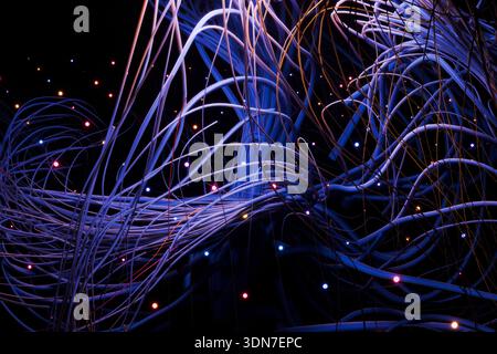Chaotic yet beautiful 3D render of data streams. Glowing points of light represent information packets moving through a complex web of interconnected Stock Photo