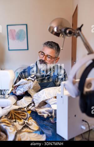 Tailor man working on fabric with sewing machine Stock Photo