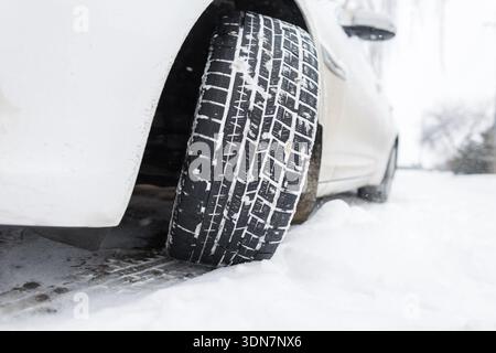 High-quality winter tires provides excellent grip and traction on a slippery, snow-covered winter street. Car tire leaving tracks in the fresh snow, s Stock Photo