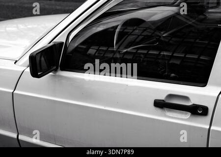 Close-up of a car through the window, looking at the steering wheel, in black and white Stock Photo