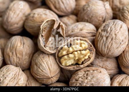 Walnuts on dark vintage table, Walnuts kernels in wooden bowl. Walnut healthy food Stock Photo
