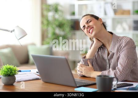 Self employed suffering neck ache while working at home Stock Photo