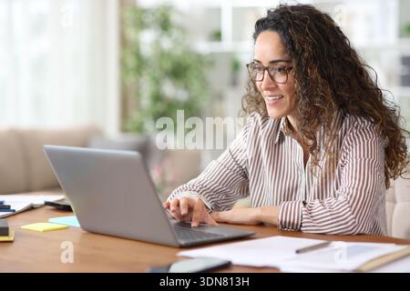 Happy freelancer working online using laptop at home Stock Photo