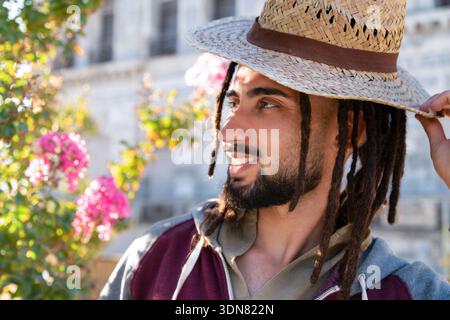 Young man wearing a straw hat with dreadlocks with Stock Photo