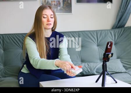 Tarot card reader holding card during online consultation on smartphone Stock Photo