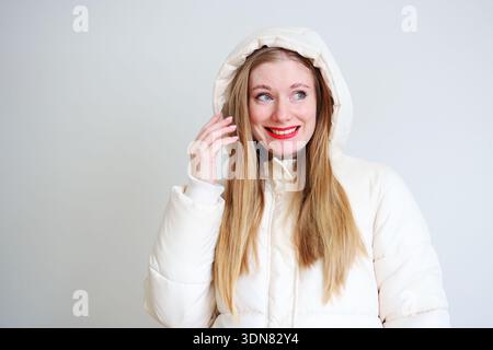 Fashion portrait of cheerful woman in cozy winter coat with bright makeup Stock Photo