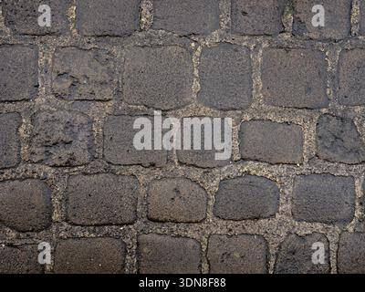 Historic town street surface made of uneven stone blocks. Stock Photo