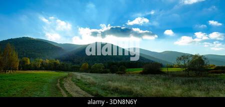 The sun setting behind a mountain. Polish Bieszczady Mountains. Stock Photo