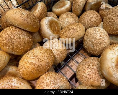 A close-up view of numerous golden brown sesame seed buns showcasing their freshly baked texture, perfect for healthy eating, a grocery store display, Stock Photo
