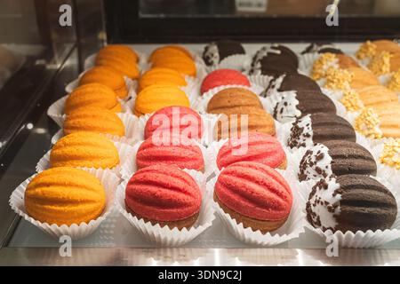 Baked in the oven colored sweet nuts with different fillings. Colorful dessert. Sweet nuts with filling. Coffee shop window. Delicious cakes. Stock Photo