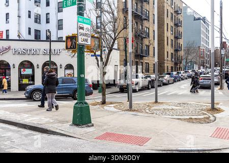 Cambreleng Triangle in Little Italy, the Bronx, NYC, with a memorial to Bishop Joseph Maria Pernicone among cobblestones in a small pedestrian plaza Stock Photo