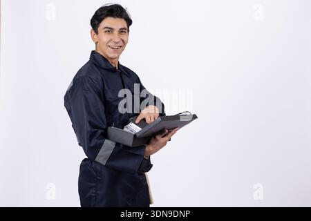Professional technician holding a tablet and a tool Stock Photo