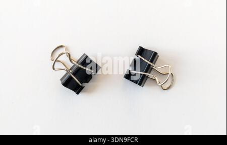 Paper clips isolated on a white background. Black binder clips, a simple yet versatile office tool for business and management, to fasten sheets of pa Stock Photo