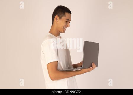 Man using laptop while standing on white background Stock Photo