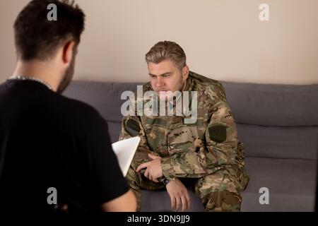 Two soldiers talking while sitting on a couch Stock Photo