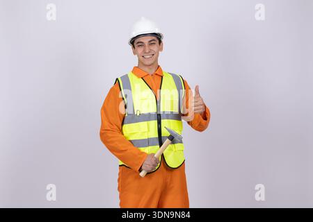 Smiling worker in safety helmet showing thumb up Stock Photo