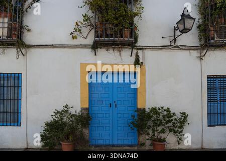 blue door with a yellow trim set against a whitewashed building in the San Basilio area of Cordoba, Spain. Stock Photo