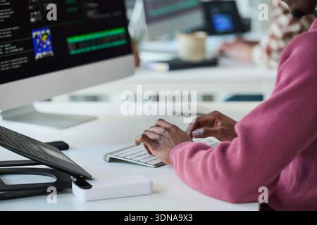 Young Black Man Typing on Keyboard While Working with Computer Monitor Stock Photo